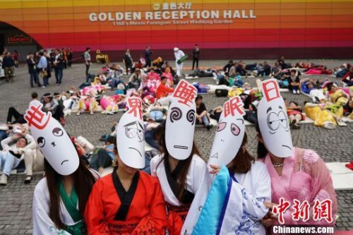 资料图：图为重庆某景区工作人员戴着“世界睡眠日”面具。 杨孝勇 摄