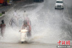 印度多地遭季风暴雨袭击 民众水中出行